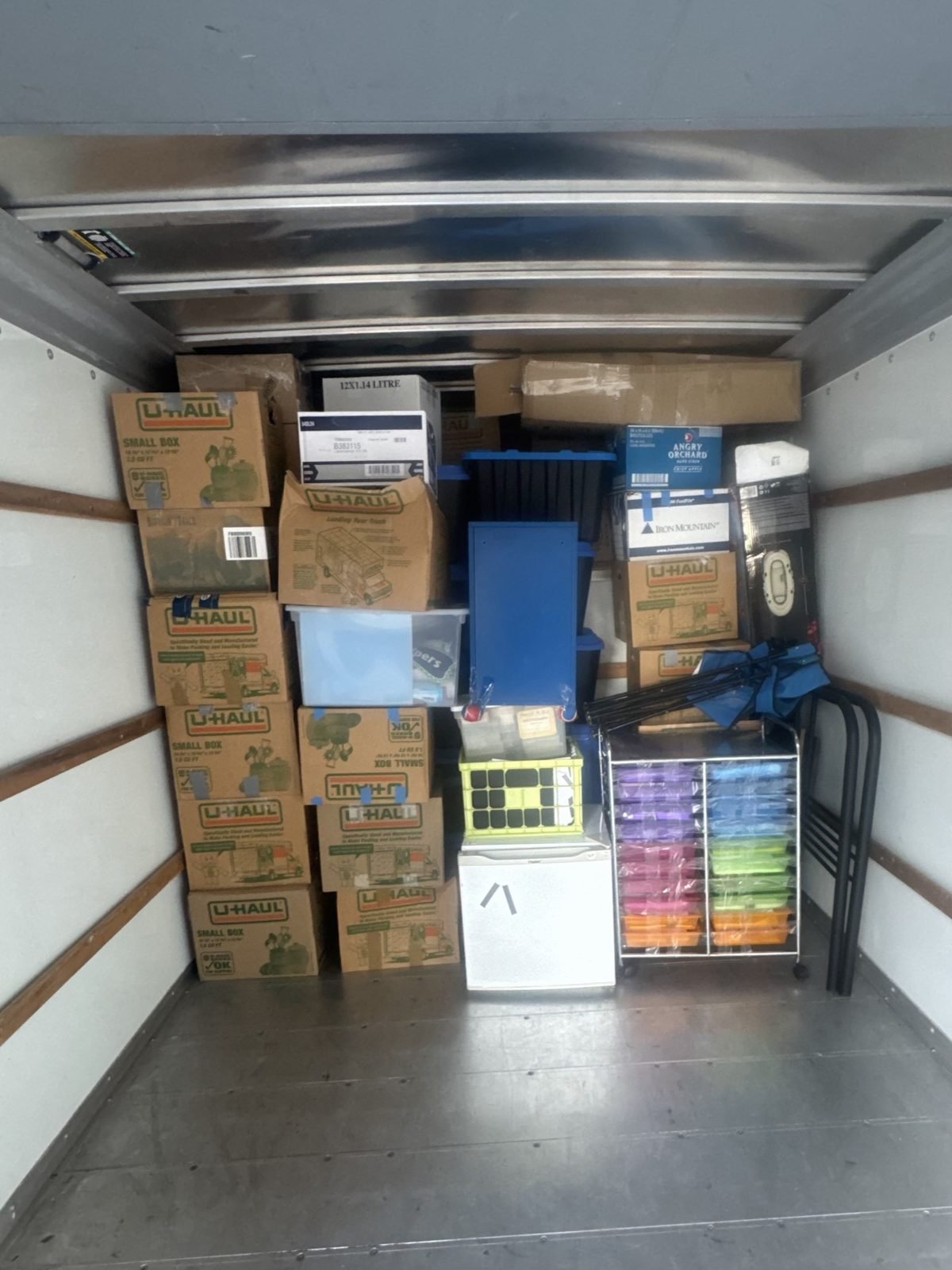A box truck densely loaded with U-Haul boxes and storage bins